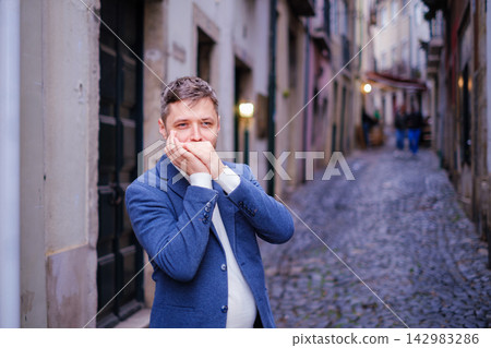 Man plays harmonica outdoors in city street Man plays harmonica outdoors in city street 142983286