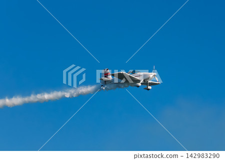 Stunt aerobatic plane performing stunts in air Stunt aerobatic plane performing stunts in air 142983290