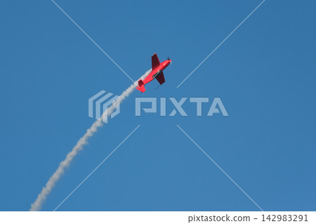 Stunt aerobatic plane performing stunts in air Stunt aerobatic plane performing stunts in air 142983291