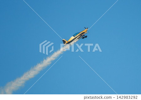 Stunt aerobatic plane performing stunts in air Stunt aerobatic plane performing stunts in air 142983292