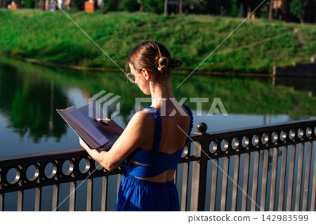 Woman reading in sunlit park. No smartphone. Cognitive refresh through pages. Self education in priority. Celebrating August 9 book lovers day Woman reading in sunlit park. No smartphone. Cognitive refresh through pages. Self education in priority. Celebrating August 9 book lovers day 142983599