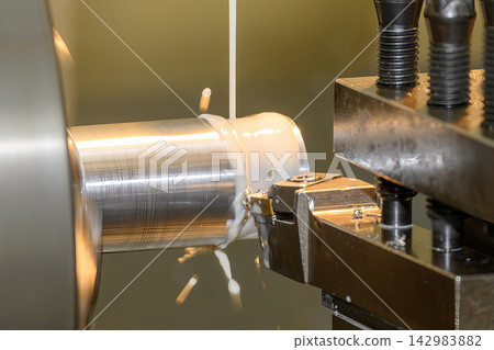 Close up of a metal shaft finish cutting process on a lathe machine using a liquid coolant method 142983882