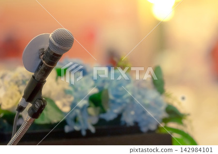 Microphone on stand at podium stage for public speaking, conference presentation and professional speech, prepared for a speaker addressing an audience during a seminar or business event. Microphone on stand at podium stage for public speaking, conference presentation and professional speech, prepared for a speaker addressing an audience during a seminar or business event. 142984101
