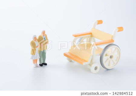 Dolls of a senior couple and a wheelchair Dolls of a senior couple and a wheelchair 142984512