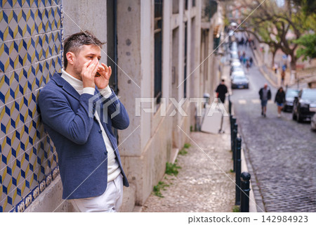 Man plays harmonica outdoors in city street Man plays harmonica outdoors in city street 142984923