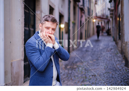 Man plays harmonica outdoors in city street Man plays harmonica outdoors in city street 142984924