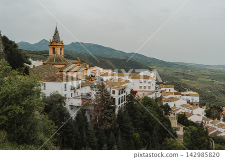 Aerial view of white village rooftops and church tower on a cliffside in Spain Aerial view of white village rooftops and church tower on a cliffside in Spain 142985820