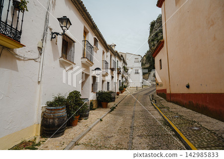 Narrow cobblestone street lined with whitewashed houses in a Spanish hill town Narrow cobblestone street lined with whitewashed houses in a Spanish hill town 142985833