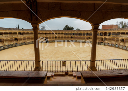 Columned view of the Ronda bullring's sandy arena and tiered stands Columned view of the Ronda bullring's sandy arena and tiered stands 142985857