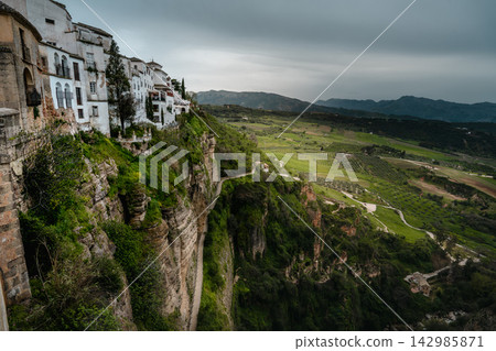 Cliffside houses of Ronda perched above the plunging El Tajo gorge Cliffside houses of Ronda perched above the plunging El Tajo gorge 142985871