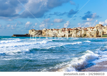Coastal village architecture overlooking the blue Mediterranean sea with rolling white waves Coastal village architecture overlooking the blue Mediterranean sea with rolling white waves 142986010