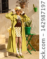 Stylish retro outfit with green trench coat and polka dot skirt in sunny courtyard 142987197