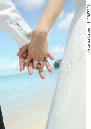 Bride and groom holding hands Bride and groom holding hands 142987338