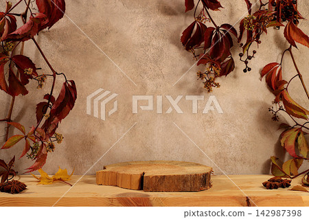 An empty birch wood food display stand adorned with red grapevines, set against a kitchen interior, minimalist autumn concept, creative fall composition, and design banner. Thanksgiving greeting card. An empty birch wood food display stand adorned with red grapevines, set against a kitchen interior, minimalist autumn concept, creative fall composition, and design banner. Thanksgiving greeting card. 142987398