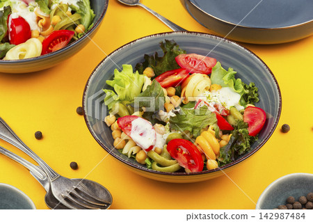 Fresh pasta and chickpea salad with leafy greens and tomatoes Fresh pasta and chickpea salad with leafy greens and tomatoes 142987484