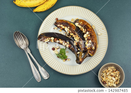 Caramelized grilled bananas with chocolate spread and chopped nuts. Caramelized grilled bananas with chocolate spread and chopped nuts. 142987485