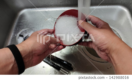 A scene of washing bowls in the kitchen sink. A scene of washing bowls in the kitchen sink. 142988016