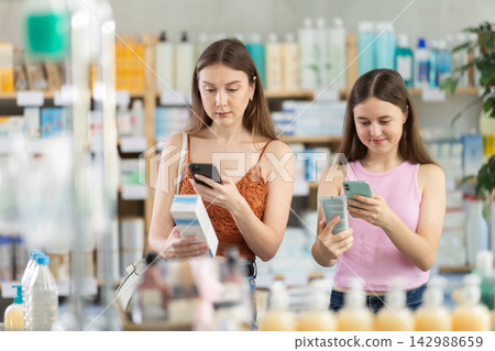 Woman with daughter scanning qr code of cream 142988659