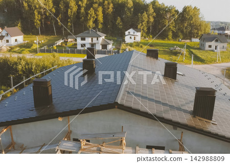 dark gray roof of an industrial building made of metal. Corrugated metal roof and metal roofing. Modern roof made of met dark gray roof of an industrial building made of metal. Corrugated metal roof and metal roofing. Modern roof made of met 142988809