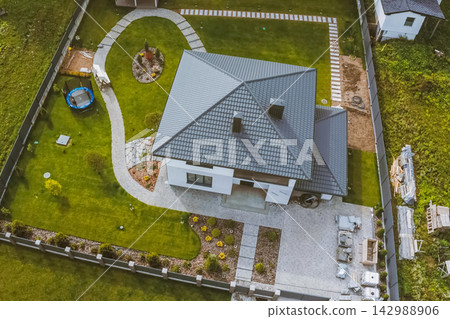 House with a gray metal roof. Corrugated metal roof and metal roofing. Modern roof made of metal. House with a gray metal roof. Corrugated metal roof and metal roofing. Modern roof made of metal. 142988906