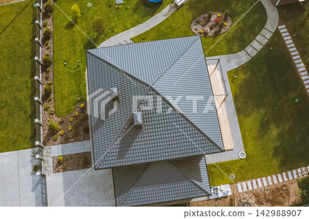 House with a gray metal roof. Corrugated metal roof and metal roofing. Modern roof made of metal. House with a gray metal roof. Corrugated metal roof and metal roofing. Modern roof made of metal. 142988907