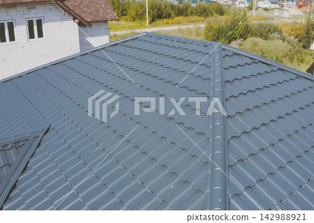 Corrugated metal roof and metal roofing. Modern roof made of met Corrugated metal roof and metal roofing. Modern roof made of met 142988921