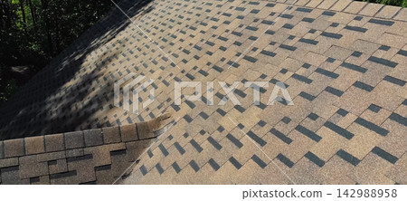 Bituminous tile for a roof. a roof from a bituminous tile. Modern roof made of met Bituminous tile for a roof. a roof from a bituminous tile. Modern roof made of met 142988958