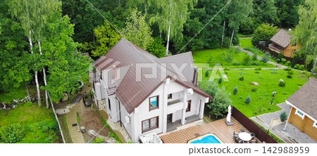 new house, the roof of which is made of metal. Cottage in the countryside. new house, the roof of which is made of metal. Cottage in the countryside. 142988959