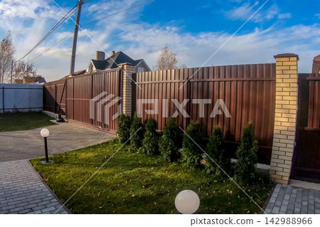 Fence and gate made of brown corrugated metal profile Fence and gate made of brown corrugated metal profile 142988966