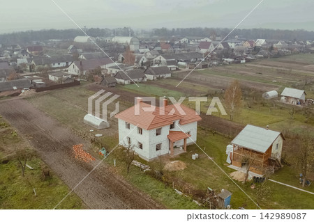 New houses under construction in the village. Houses with a roof made of metal. Corrugated metal roof and metal roofing. Modern roof made of metal. 142989087