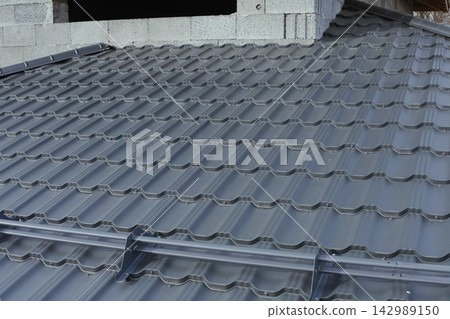 Corrugated metal roof and metal roofing. Modern roof made of metal. Corrugated metal roof and metal roofing. Modern roof made of metal. 142989150