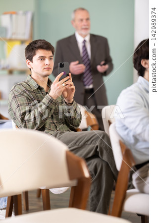 guy scans a barcode during a lecture in front of a teacher guy scans a barcode during a lecture in front of a teacher 142989374