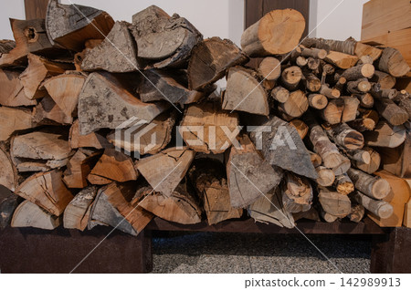 Firewood piled up on the dirt floor 142989913