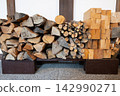 Firewood piled up on the dirt floor 142990271