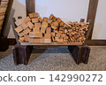 Firewood piled up on the dirt floor 142990272
