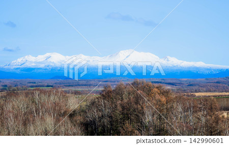 秋季,從美瑛的山丘上眺望大雪山山脈和旭岳的壯麗景色,映襯著湛藍的天空。 秋季,從美瑛的山丘上眺望大雪山山脈和旭岳的壯麗景色,映襯著湛藍的天空。 142990601