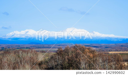 秋季,從美瑛的山丘上眺望大雪山山脈和旭岳的壯麗景色,映襯著湛藍的天空。 秋季,從美瑛的山丘上眺望大雪山山脈和旭岳的壯麗景色,映襯著湛藍的天空。 142990602