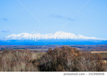 秋季,從美瑛的山丘上眺望大雪山山脈和旭岳的壯麗景色,映襯著湛藍的天空。 秋季,從美瑛的山丘上眺望大雪山山脈和旭岳的壯麗景色,映襯著湛藍的天空。 142990606