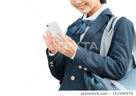 Junior high and high school girls in school uniforms looking at their smartphones. Junior high and high school girls in school uniforms looking at their smartphones. 142990979