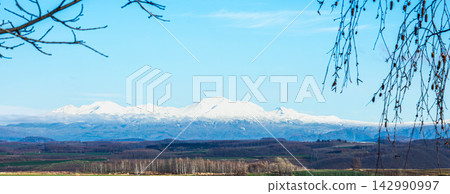 The magnificent scenery of the Daisetsuzan mountain range and Mount Asahidake, viewed from the hills of Biei, Hokkaido in autumn. The magnificent scenery of the Daisetsuzan mountain range and Mount Asahidake, viewed from the hills of Biei, Hokkaido in autumn. 142990997