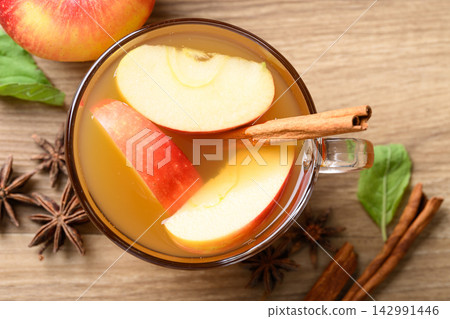 Fresh apple cider in a glass with cinnamon stick, star anise and sliced red appless 142991446