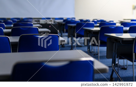 Focus on the blue chairs and white table in the conference room, and the chair in the foreground. 142991972