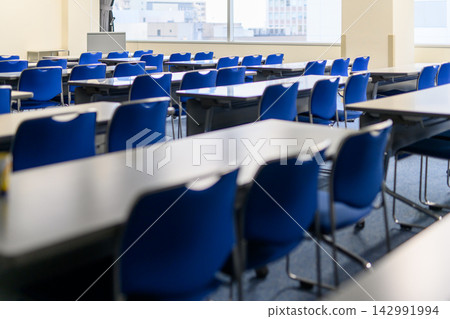 A scene from a conference room: neatly arranged blue chairs and tables. A scene from a conference room: neatly arranged blue chairs and tables. 142991994