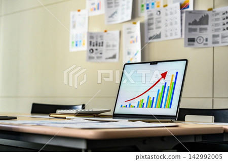 A laptop and calculator displaying graphs A laptop and calculator displaying graphs 142992005