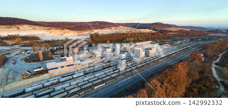 Aerial view of cargo train loaded with crushed sandstone materials at mine factory. Railway transportation of open pit mining ore Aerial view of cargo train loaded with crushed sandstone materials at mine factory. Railway transportation of open pit mining ore 142992332