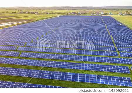 Blue solar photo voltaic panels system producing renewable clean energy on rural landscape and setting sun background. Blue solar photo voltaic panels system producing renewable clean energy on rural landscape and setting sun background. 142992931