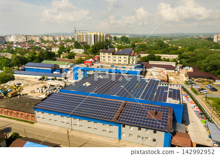 Aerial view of many photo voltaic solar panels mounted of industrial building roof. Aerial view of many photo voltaic solar panels mounted of industrial building roof. 142992952