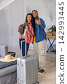 Couple posing for selfie with man holding phone and woman holding passport near suitcase in attic 142993445