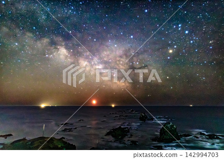A starry nightscape where the glittering Milky Way stretches across the Far Eastern night sky and the lights of the horizon intertwine. A starry nightscape where the glittering Milky Way stretches across the Far Eastern night sky and the lights of the horizon intertwine. 142994703