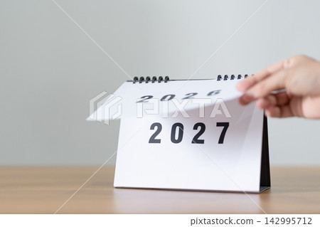 2026 to 2027 New Year Concept. Hand Turning Calendar Page Representing New Beginning, Year Transition, Future Planning, Change, Growth, Goal Setting and Fresh Start 142995712
